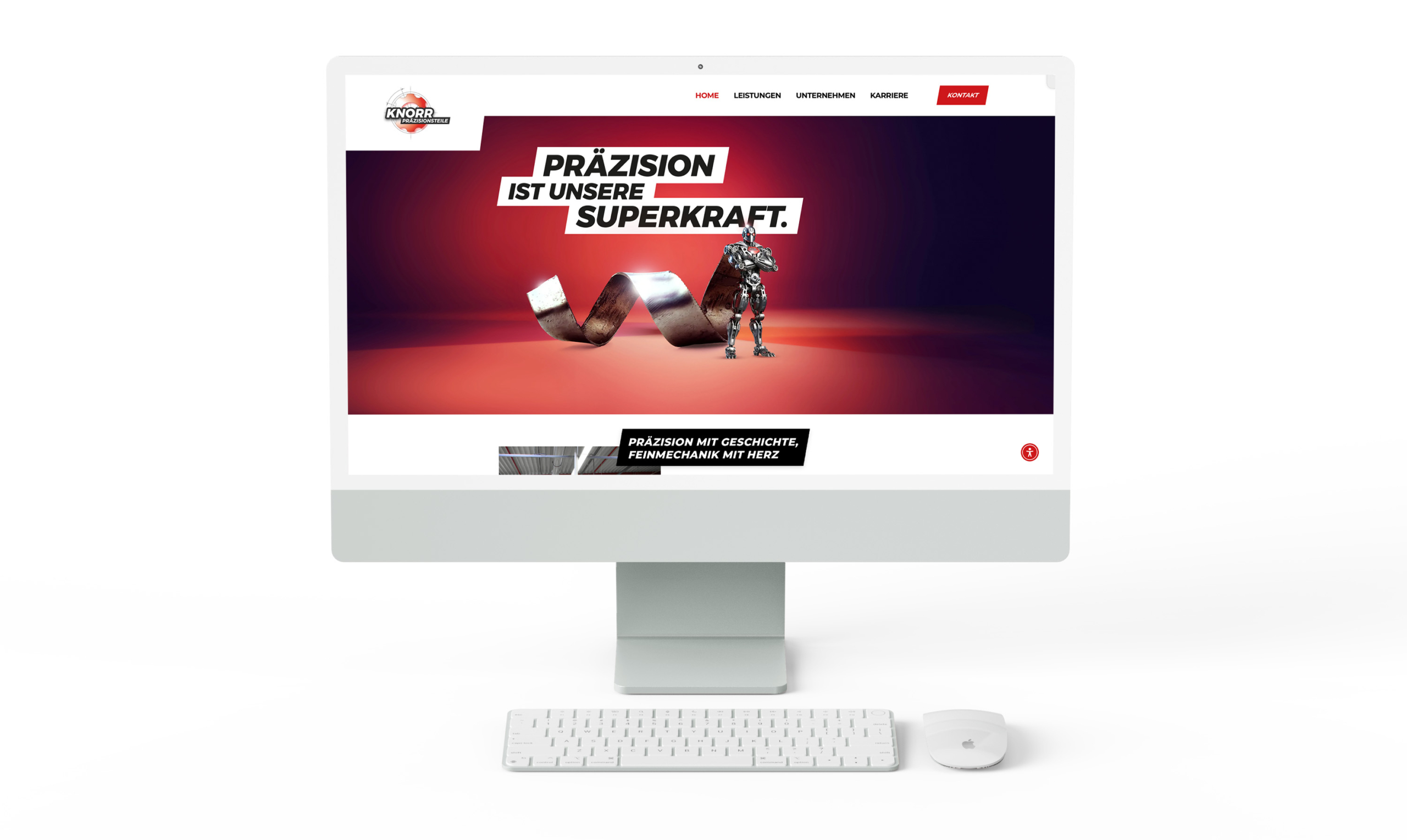 Ein weißer Desktop-Computer zeigt eine Website mit dem Slogan PRÄZISION IST UNSERE SUPERKRAFT neben einem Roboter und Metallteilen auf einem roten und schwarzen Hintergrund. Vor dem Monitor befinden sich eine weiße Tastatur und eine Maus.