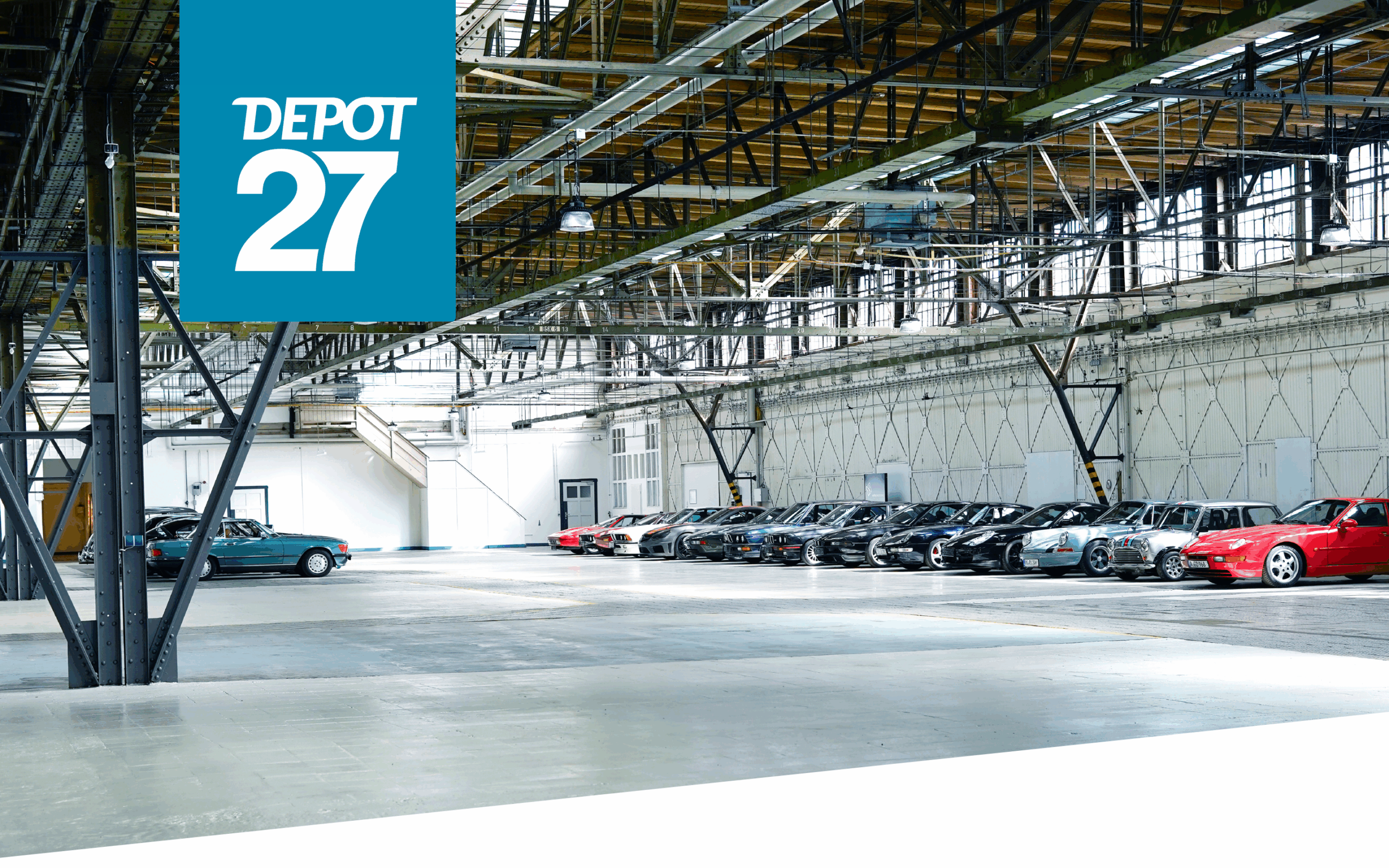 Ein geräumiges Industrielager mit einer Reihe verschiedener Autos, die an einer Wand geparkt sind; in der Ecke steht ein großes blau-weißes Schild mit der Aufschrift DEPOT 27.